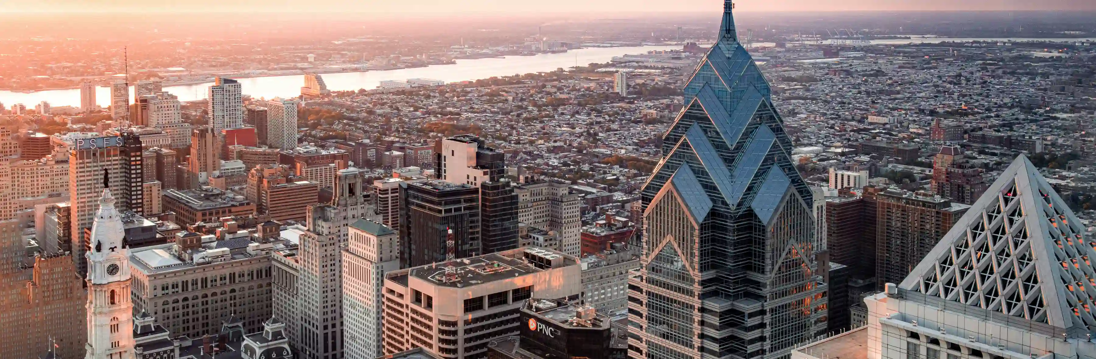 Aerial view of Philadelphia skyline at sunset, with City Hall and the Delaware River