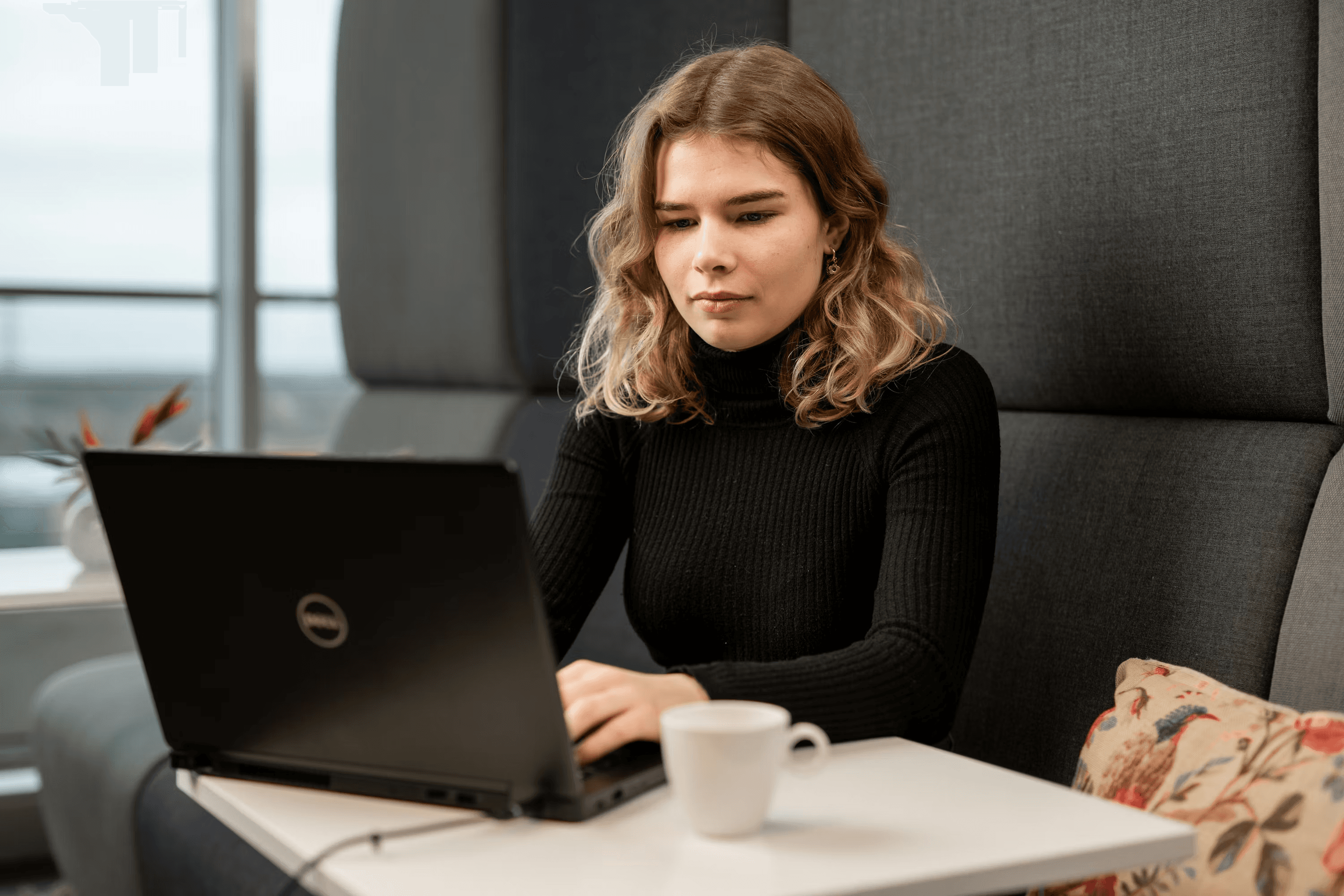 High school student reviewing research ethics guidelines at a desk with academic journals and a laptop