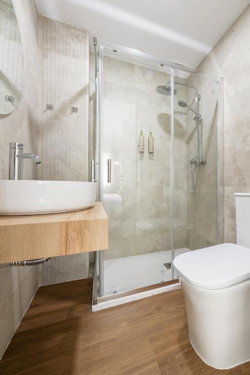 Casa Jazmín Granada: Bathroom with a glass shower, vessel sink and wood vanity