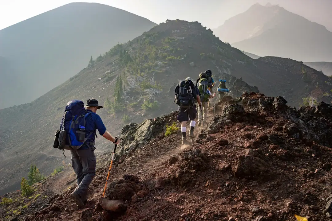 Hikers with packs on walking along a ridgeline