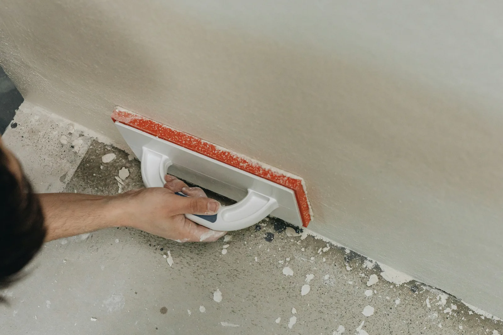 Worker applying plaster or waterproofing compound to wall with trowel