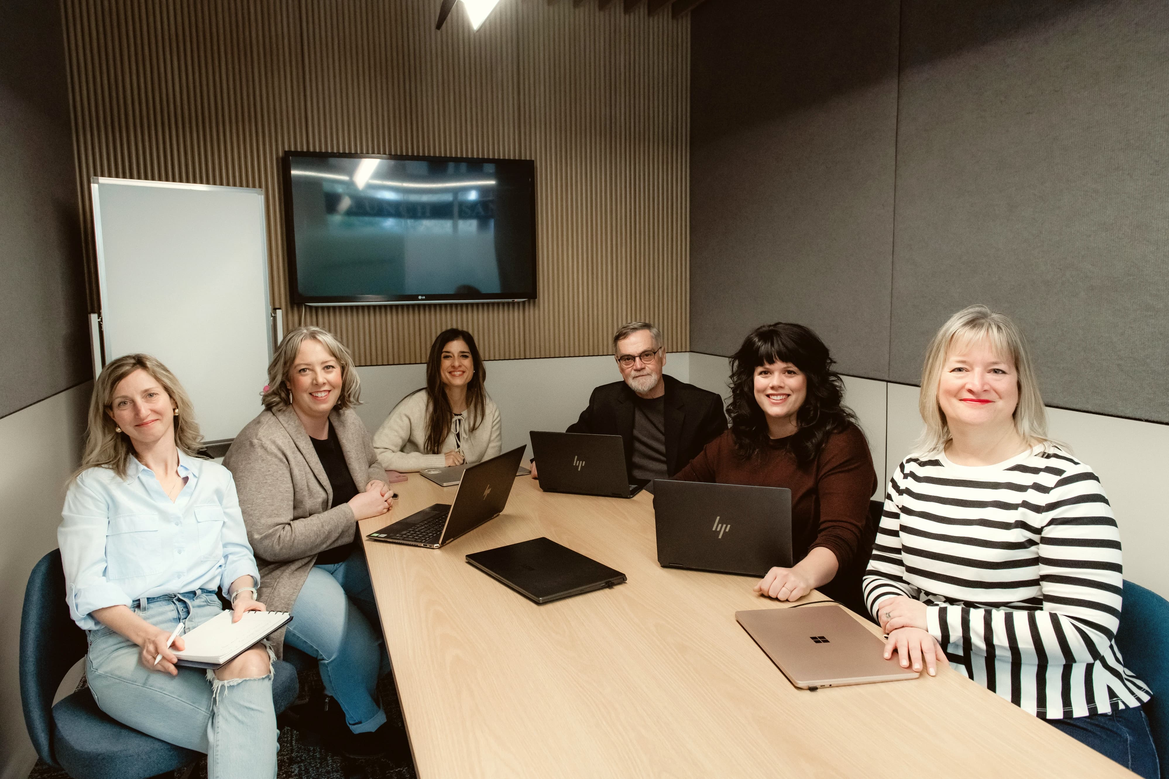 Lantern HR team seated around a meeting table with laptops in a modern office.