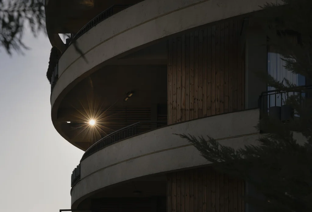 Close-up of round building at sunset with sunburst peeking through the structure