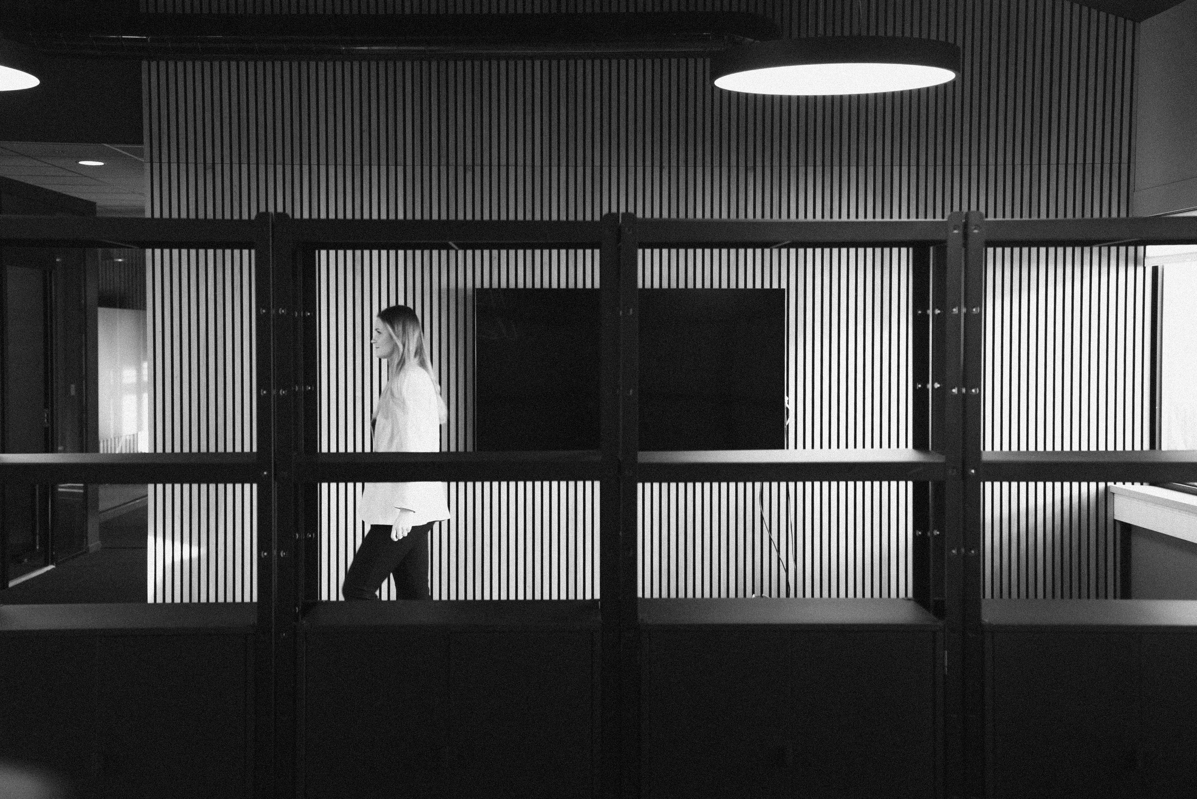 Kvinne som går forbi en skjerm i et kontorlandskap