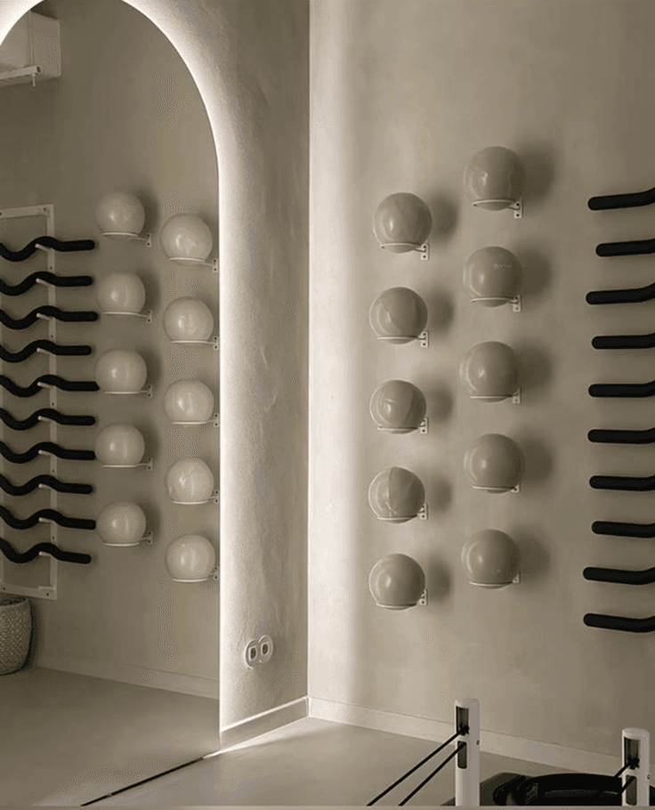 A serene spa setting with two lounge chairs beside a warm, reflective pool and soft, natural lighting.