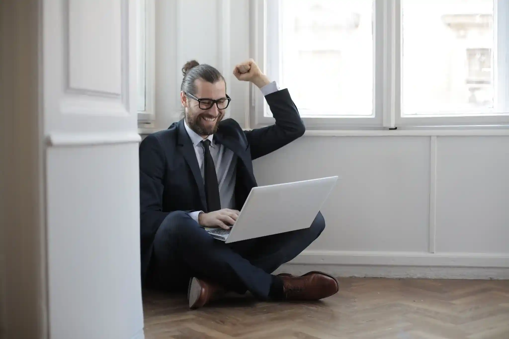 Business professional celebrating a successful online project while working on a laptop, representing digital business growth and productivity.