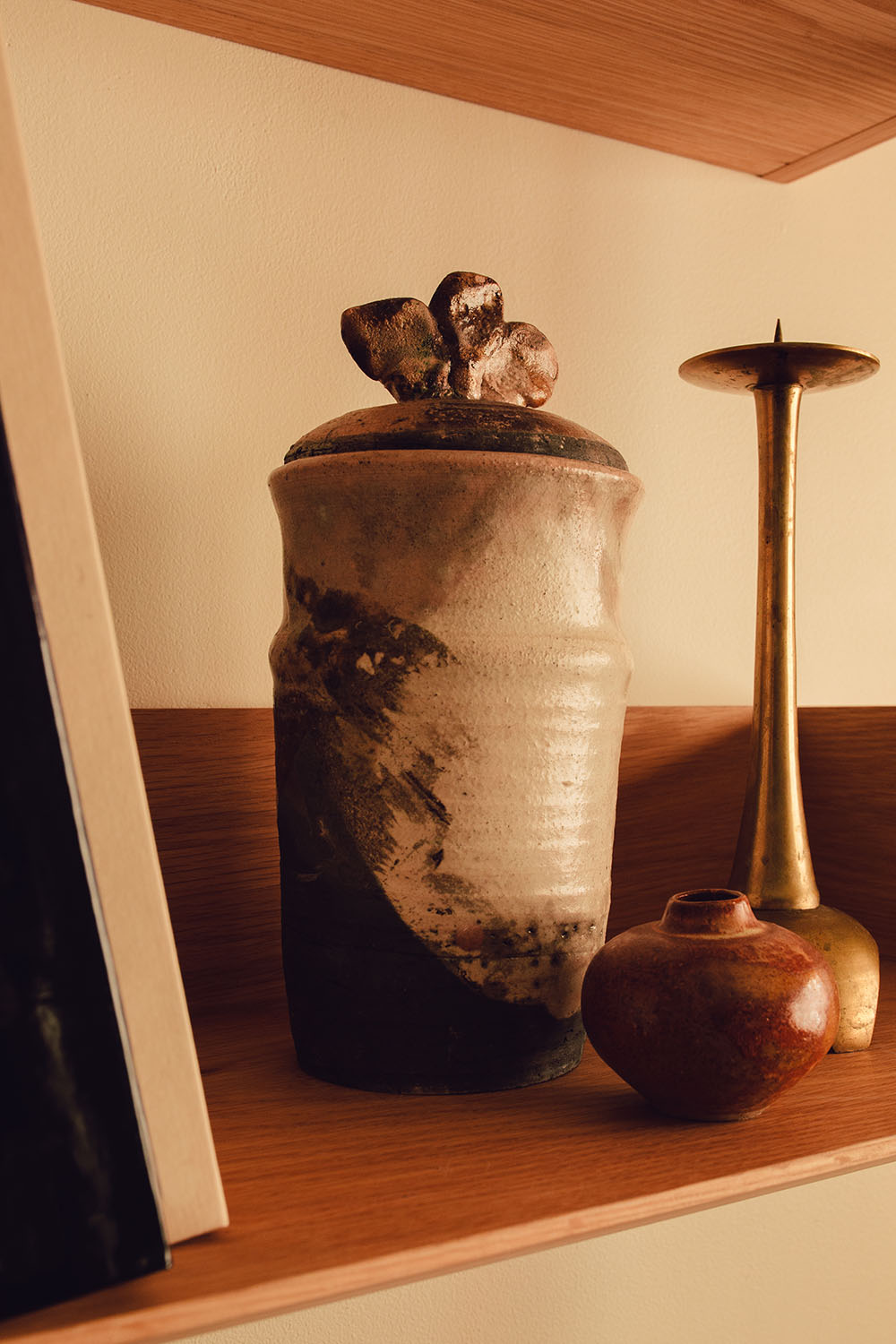 A designer vase and candle holder resting on a shelf bathed in sunlight in the lobby of Particle Studios in Seattle, WA.