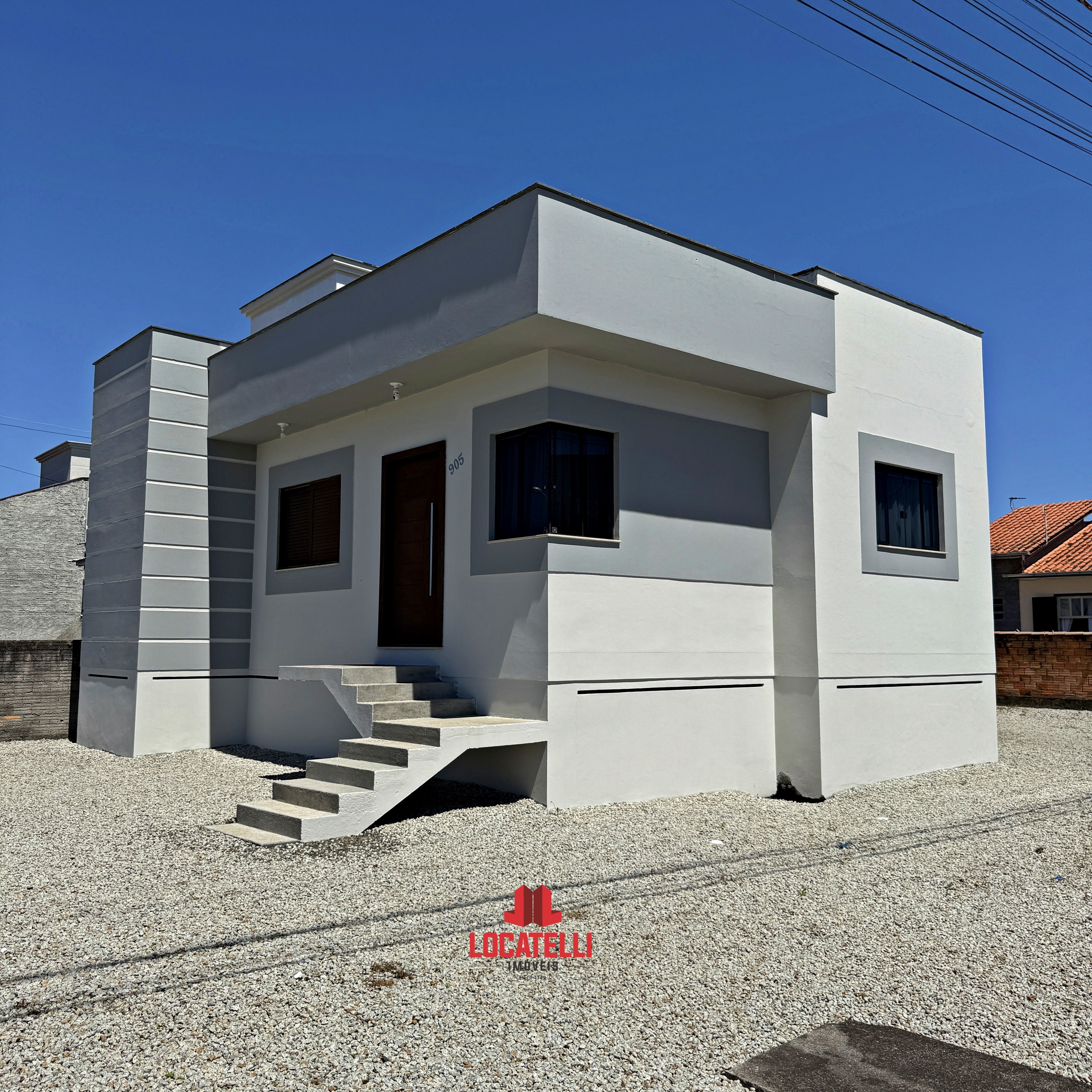 A modern brick house with a two-car garage, well-manicured lawn, and clear blue sky in the background.