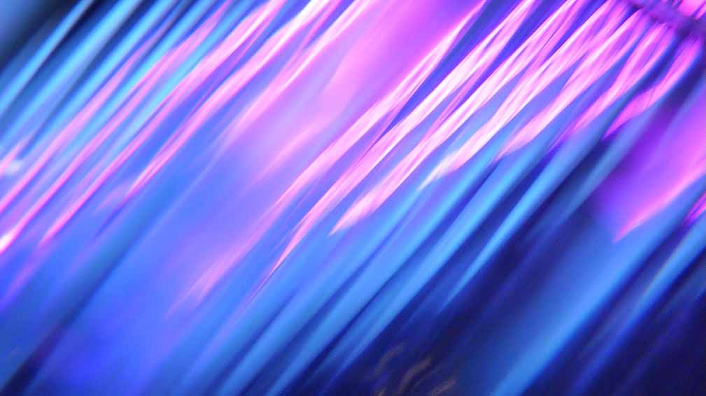Dynamische diagonale Lichtstreifen in Blau- und Pinktönen mit Bewegungsunschärfe