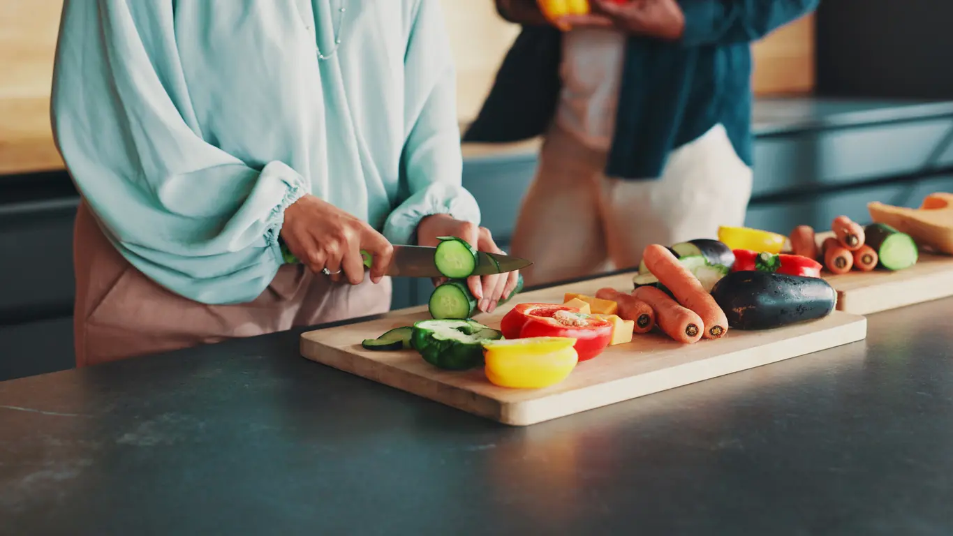 Person chopping fresh vegetables on a wooden board, illustrating healthy eating as a daily ritual that fills the resilience cup