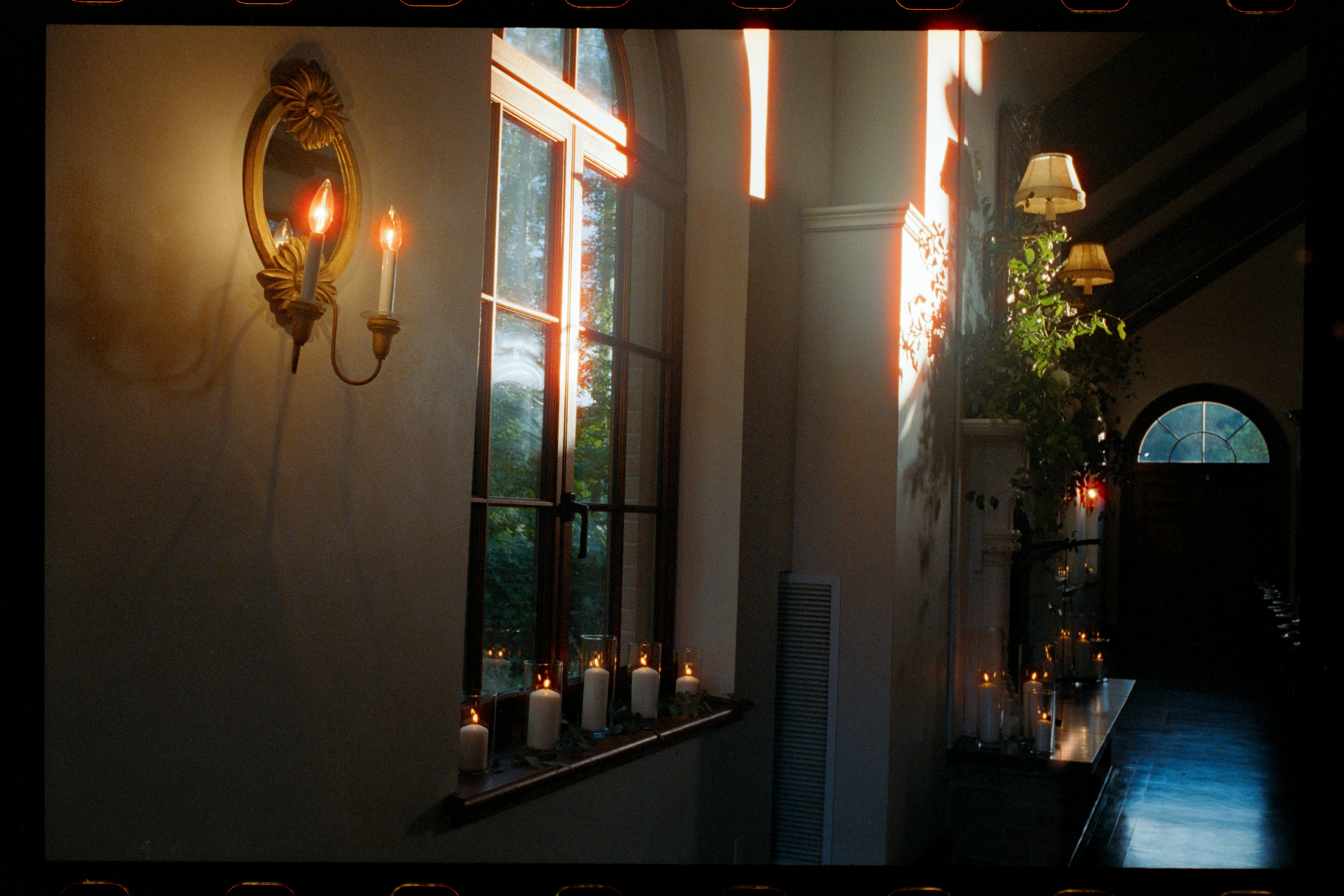Candles lit inside a house, casting a warm glow.