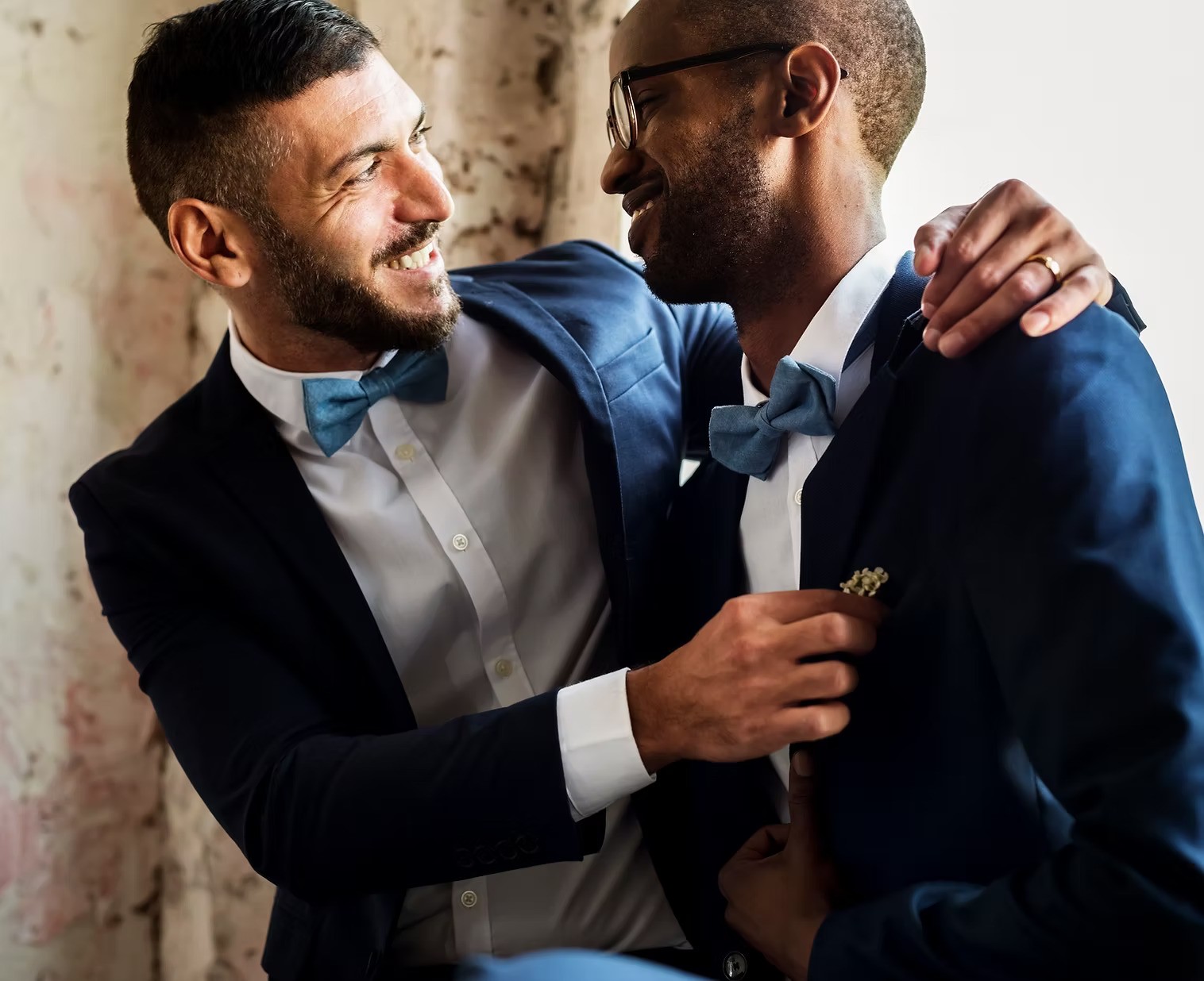 A winding road cuts through rocky terrain, surrounded by patches of green grass and illuminated by sunlight.