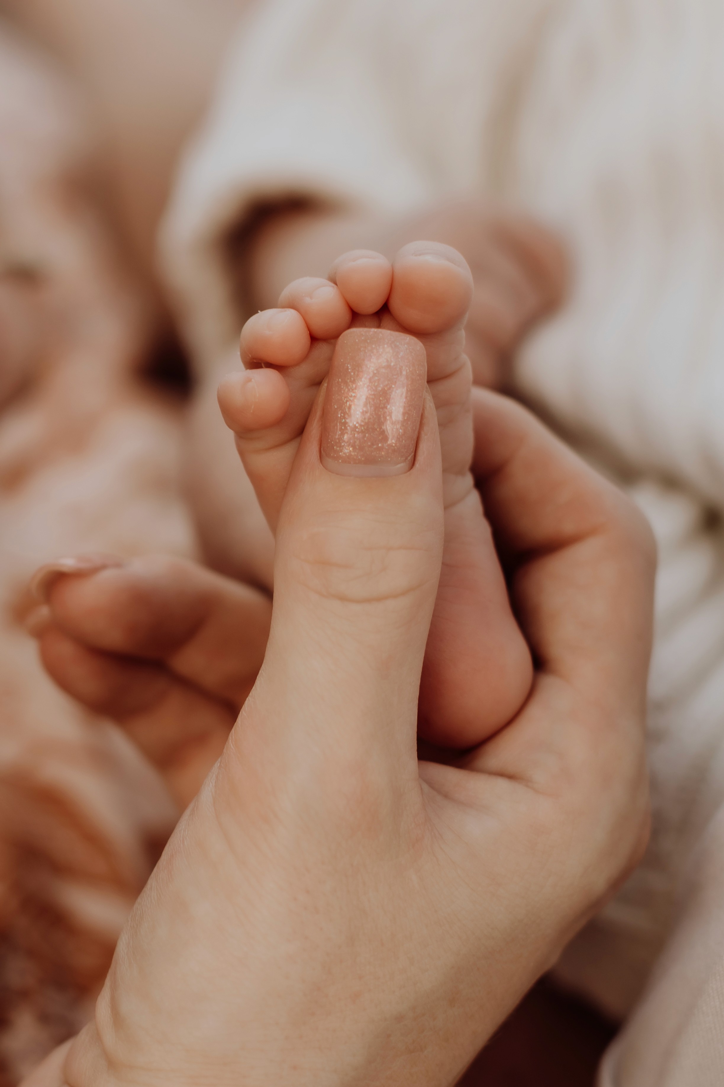 Close up of mother holding newborn baby's tiny foot in newborn photoshoot Mackay