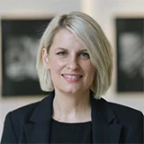 Professional headshot of Kate Boxer with short blonde hair