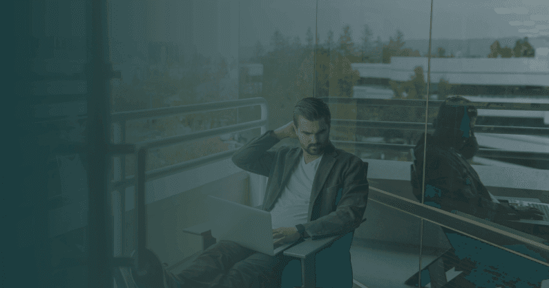 Man thinking deeply while looking at laptop