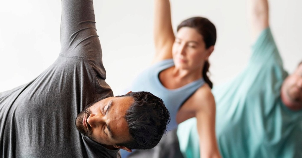 Triangle Pose in yoga: a group of people practicing the standing side stretch.