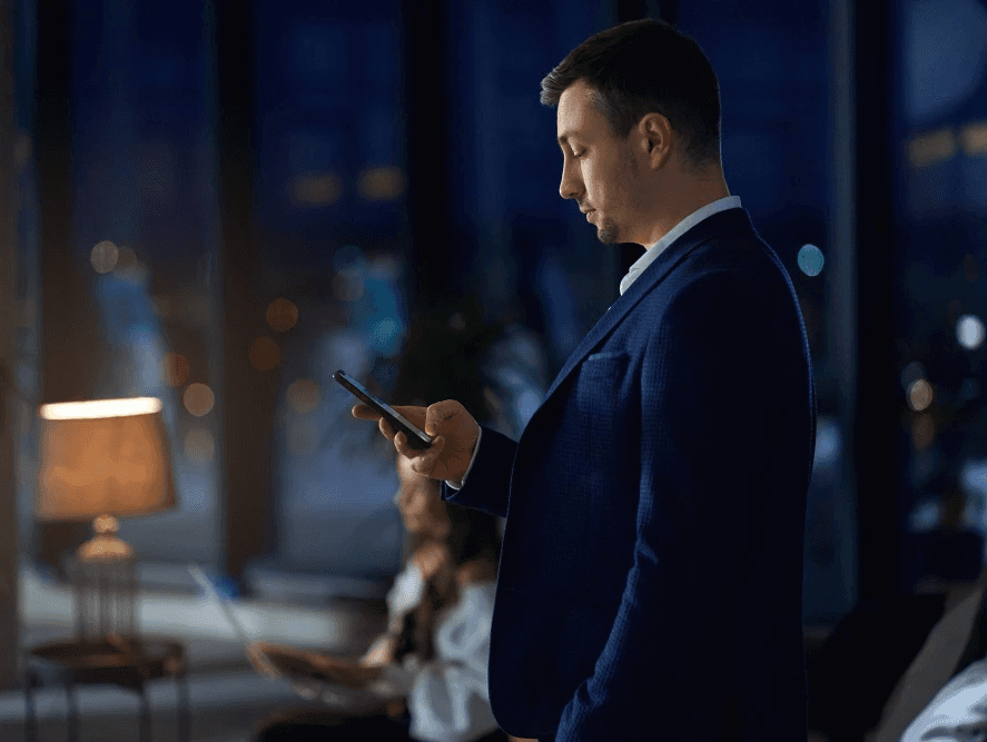 Executive man checking his phone with HoustonPlus app.
