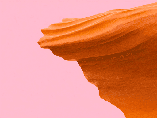 Close-up of an orange sandstone formation with smooth, wave-like curves against a pastel pink background, conveying a serene and abstract aesthetic.