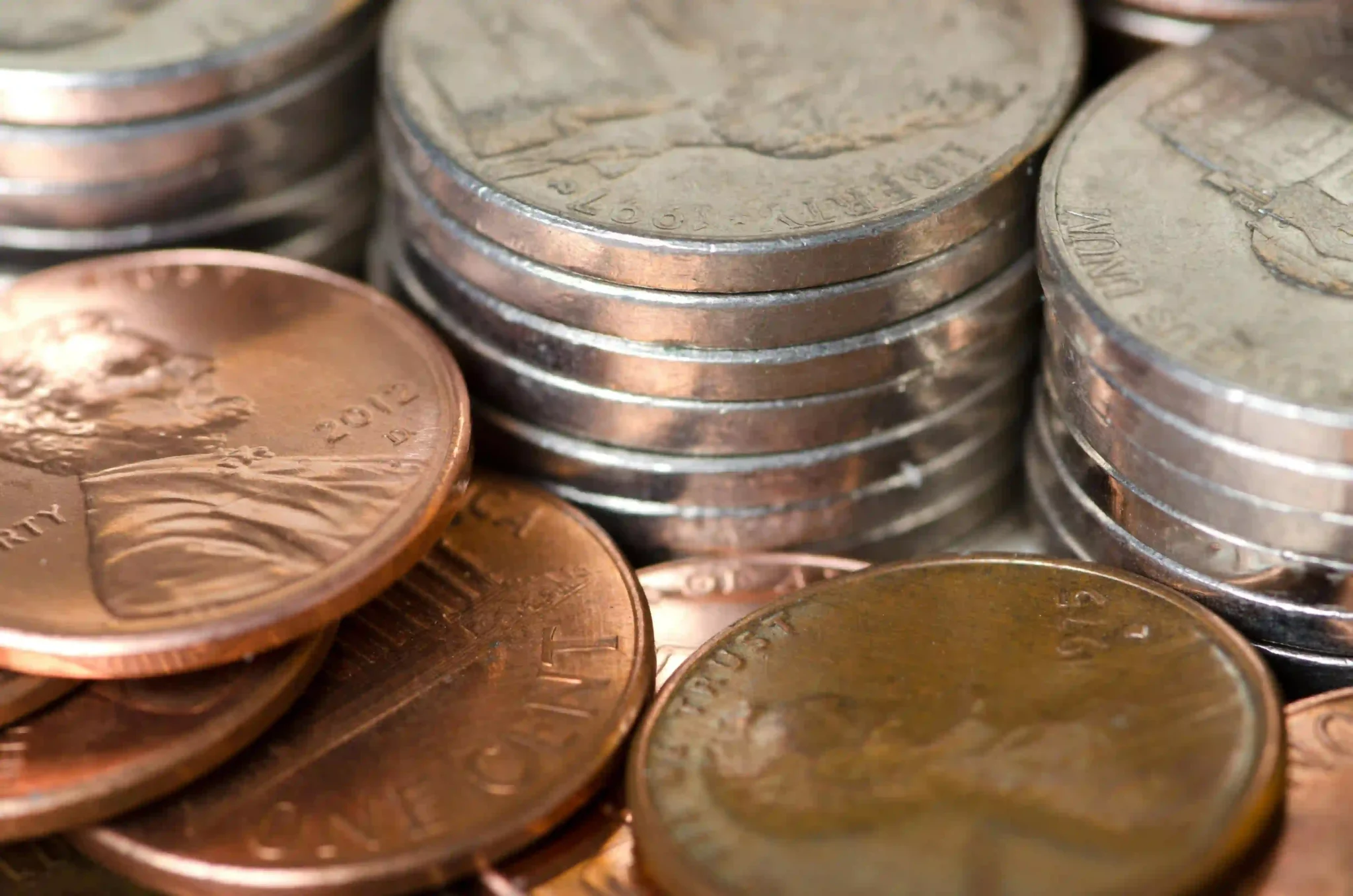 Close-up of stacked U.S. coins including pennies and nickels arranged in small piles.