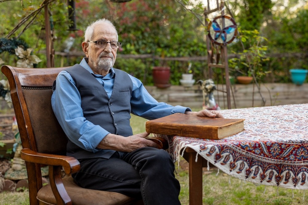 Bubjan with book and speaking to camera