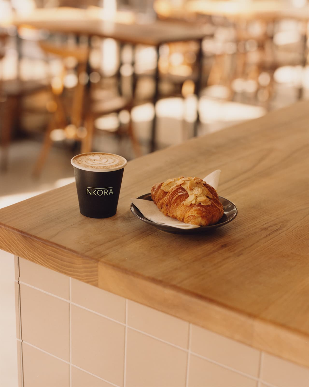 A coffee cup and an almond croissant in NKORA High Barnet Coffee Shop