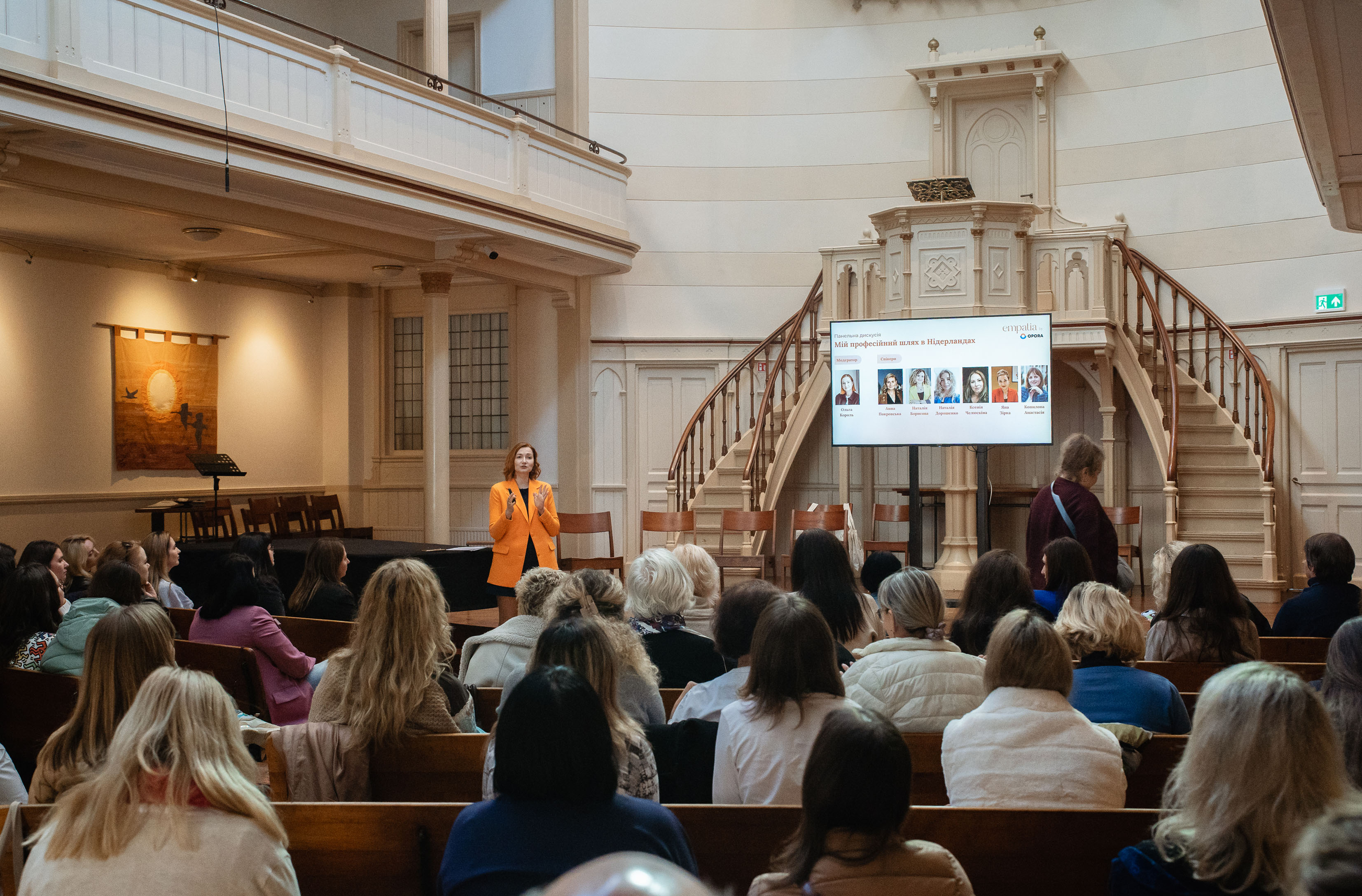Speaker addressing an audience of Ukrainian psychologists at the Empatia event, with a banner reading “Empatia” visible on stage.