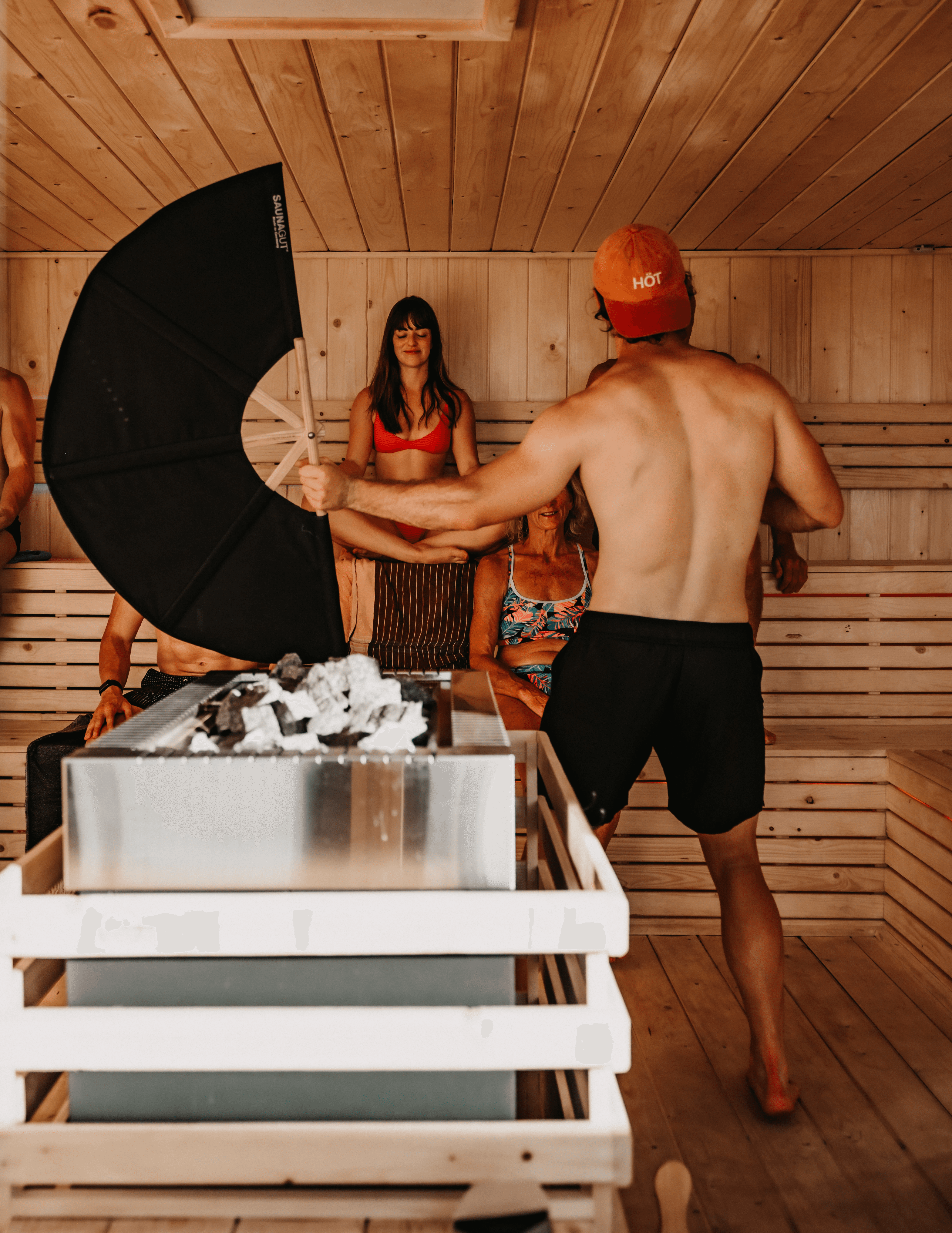 Facilitator performing a heat circulation ritual inside the SaunaHaüs wooden sauna during a guided session in Cape Town.