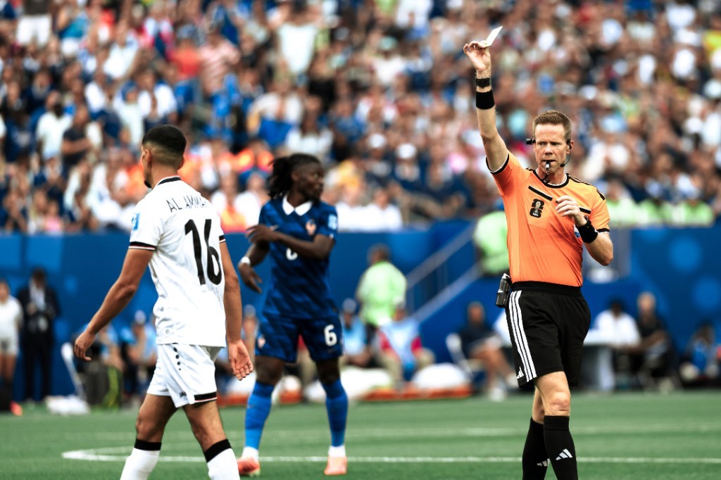 The referee shows a yellow card to Iraq's Al-Ammari during France vs Iraq at World Cup 2026