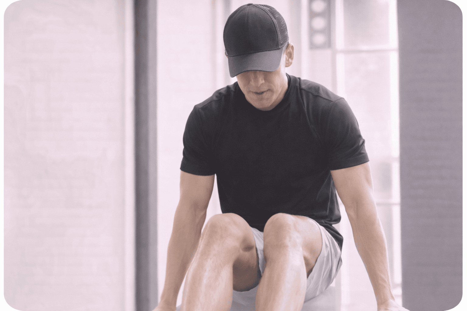 man in black crew neck t-shirt and white shorts sitting on gray concrete bench