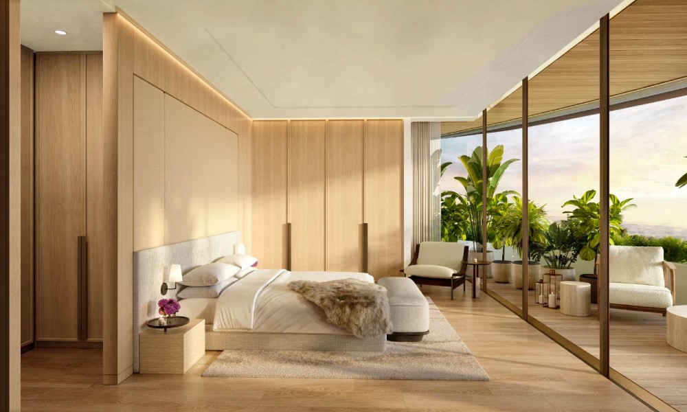 A luxurious bedroom featuring a large glass wall with a stunning view of the ocean at The Residences at Dubai Beach Edition.
