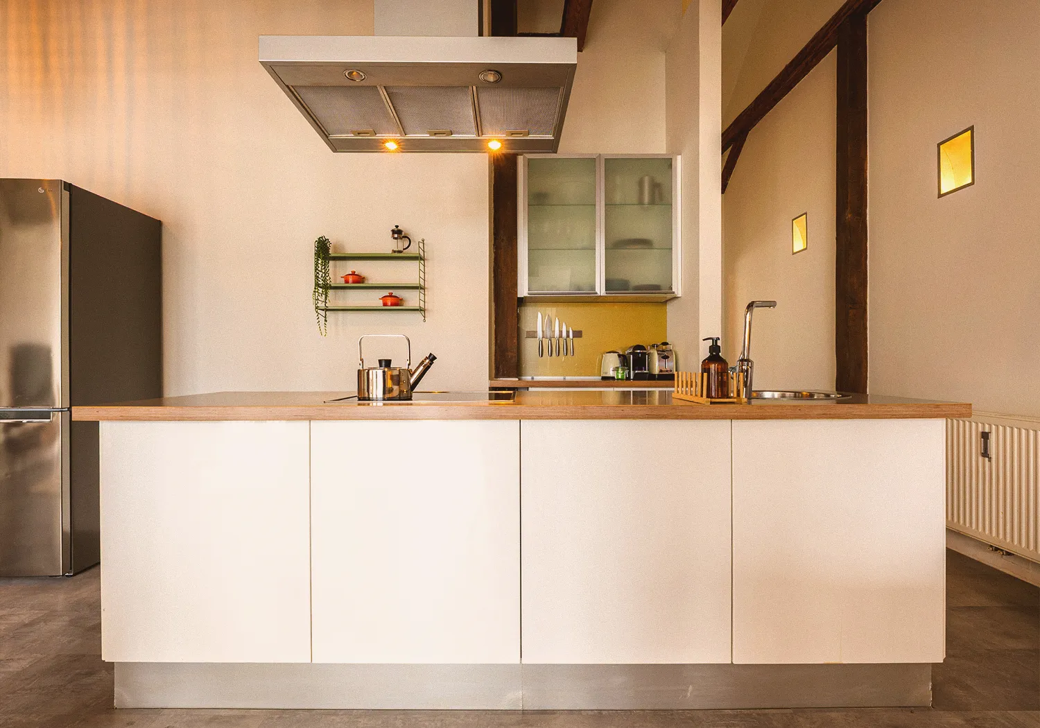 Loft N°3 • kitchen island with a wooden worktop, a steel extractor hood and a fridge