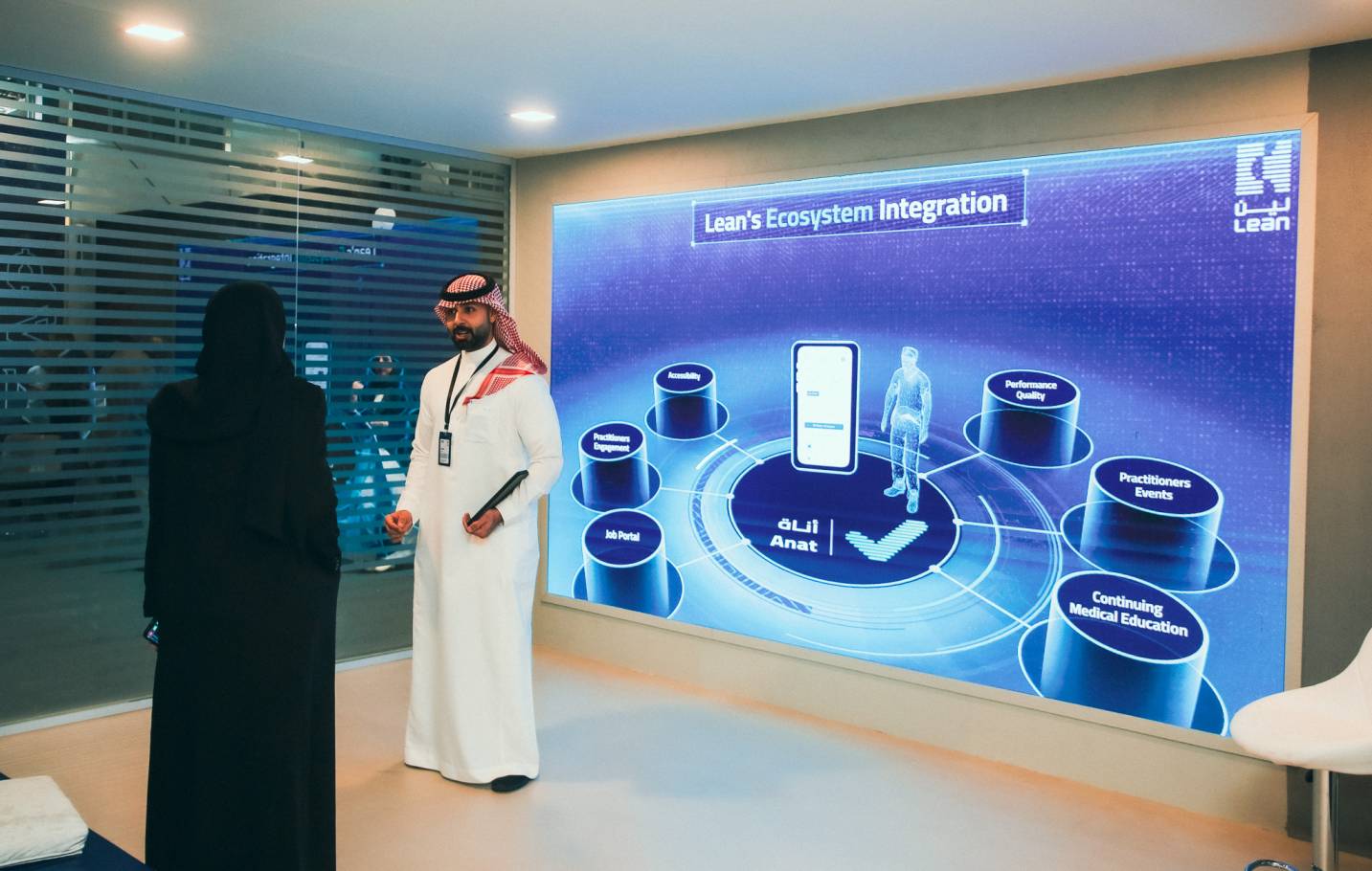 emirati man explaining to a woman in front of an interactive projection for lean at leap