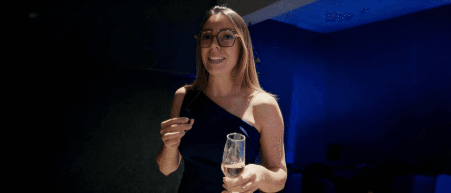 woman in brown long-sleeved top standing beside wall