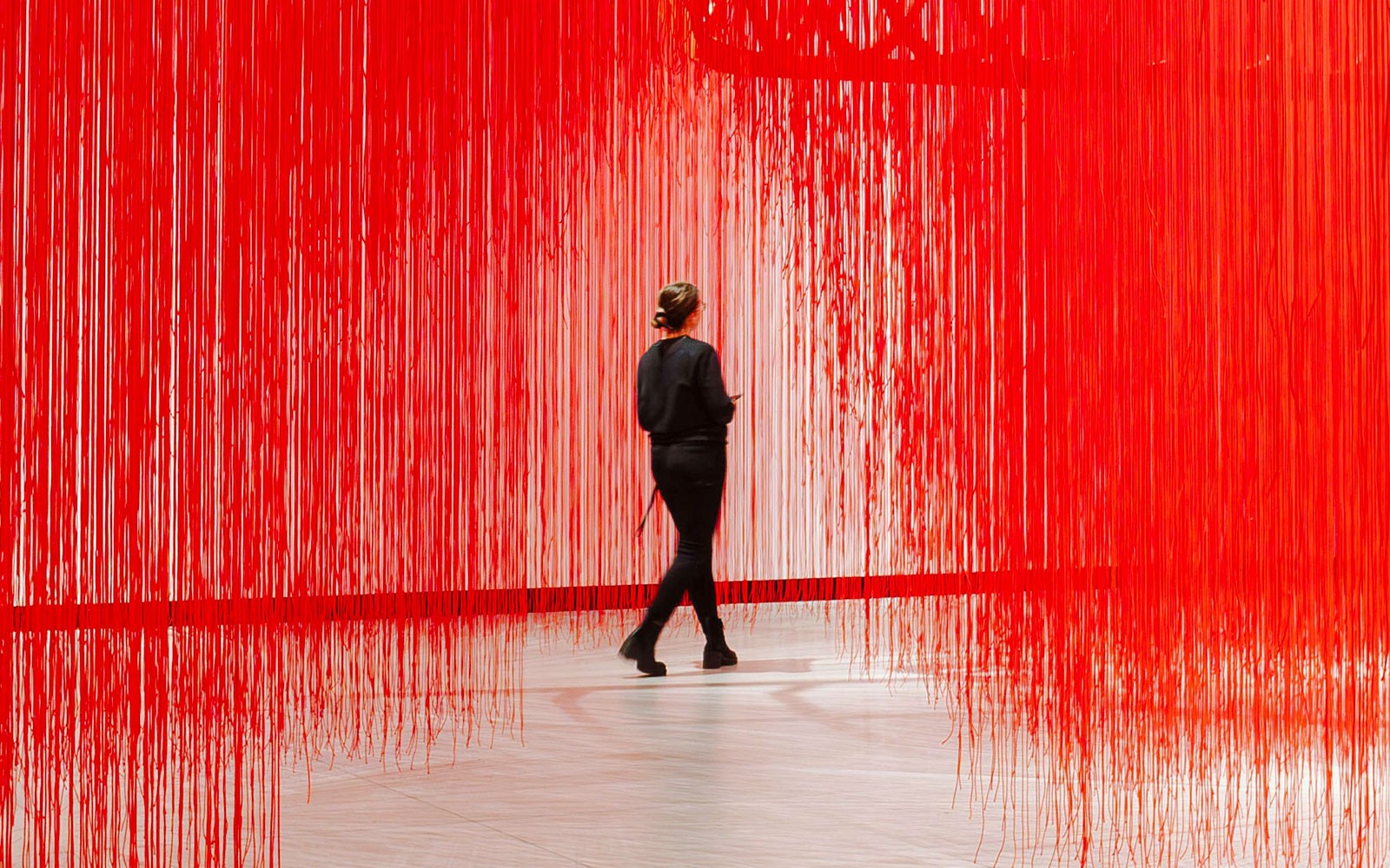 參觀者正穿過 Kunsthalle Praha 的紅色線藝裝置。