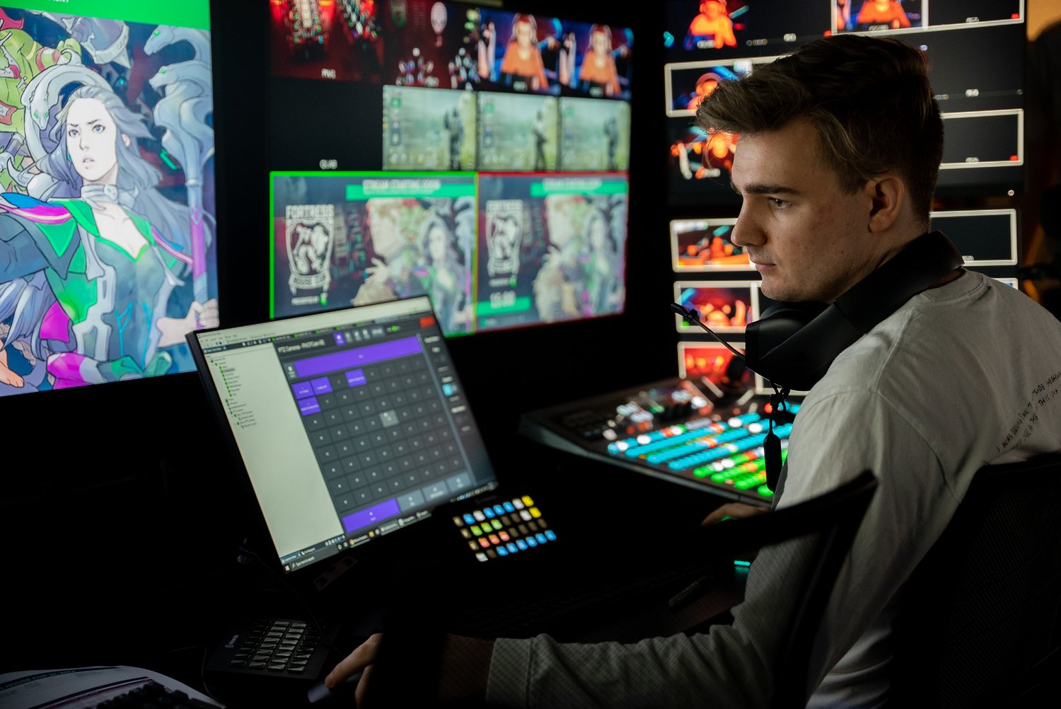 A person sitting behind screens in a broadcast studio in Fortress