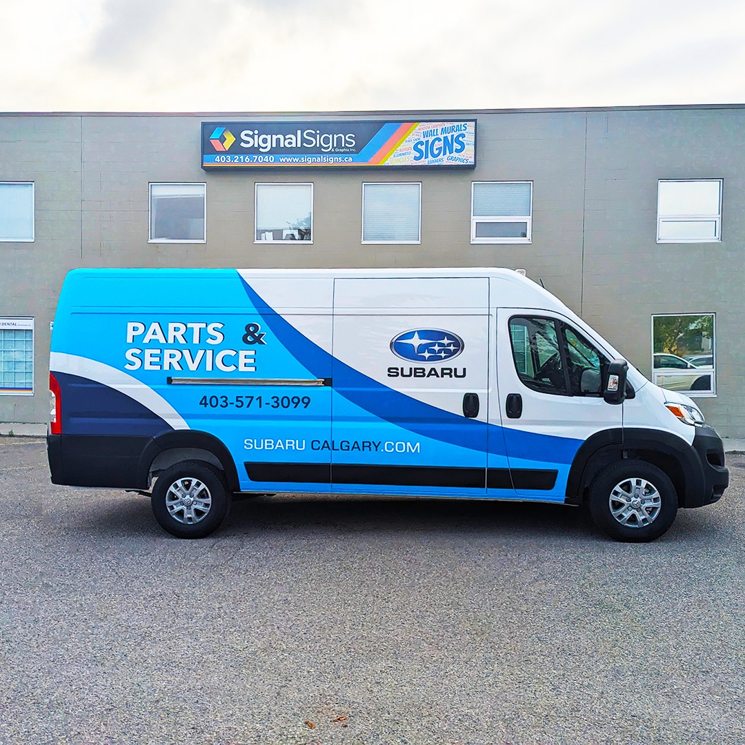 dodge windowless white van with white and blue vinyl graphics for Subaru, side view