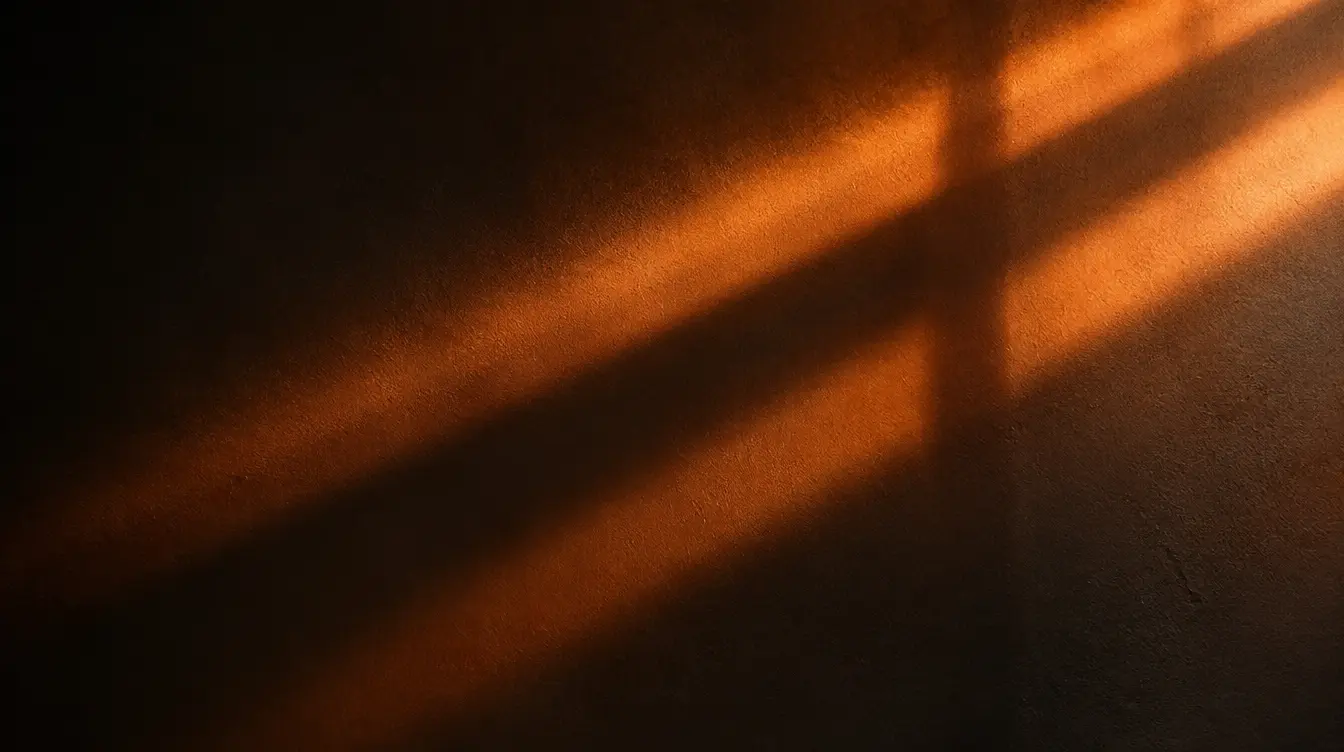 Abstract macro shot of soft orange light rays crossing a dark textured wall