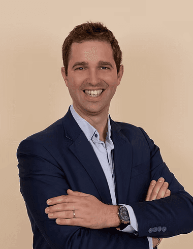 a man standing in front of a tree smiling