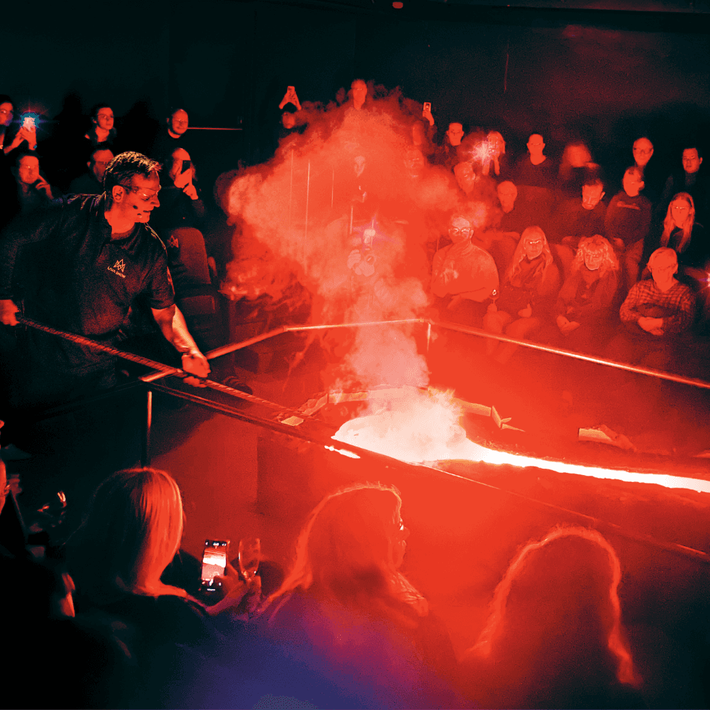 The founder of Lava Show Júlíus Ingi Jónsson demonstrates the properties of molten lava surrounded by an engaged audience.