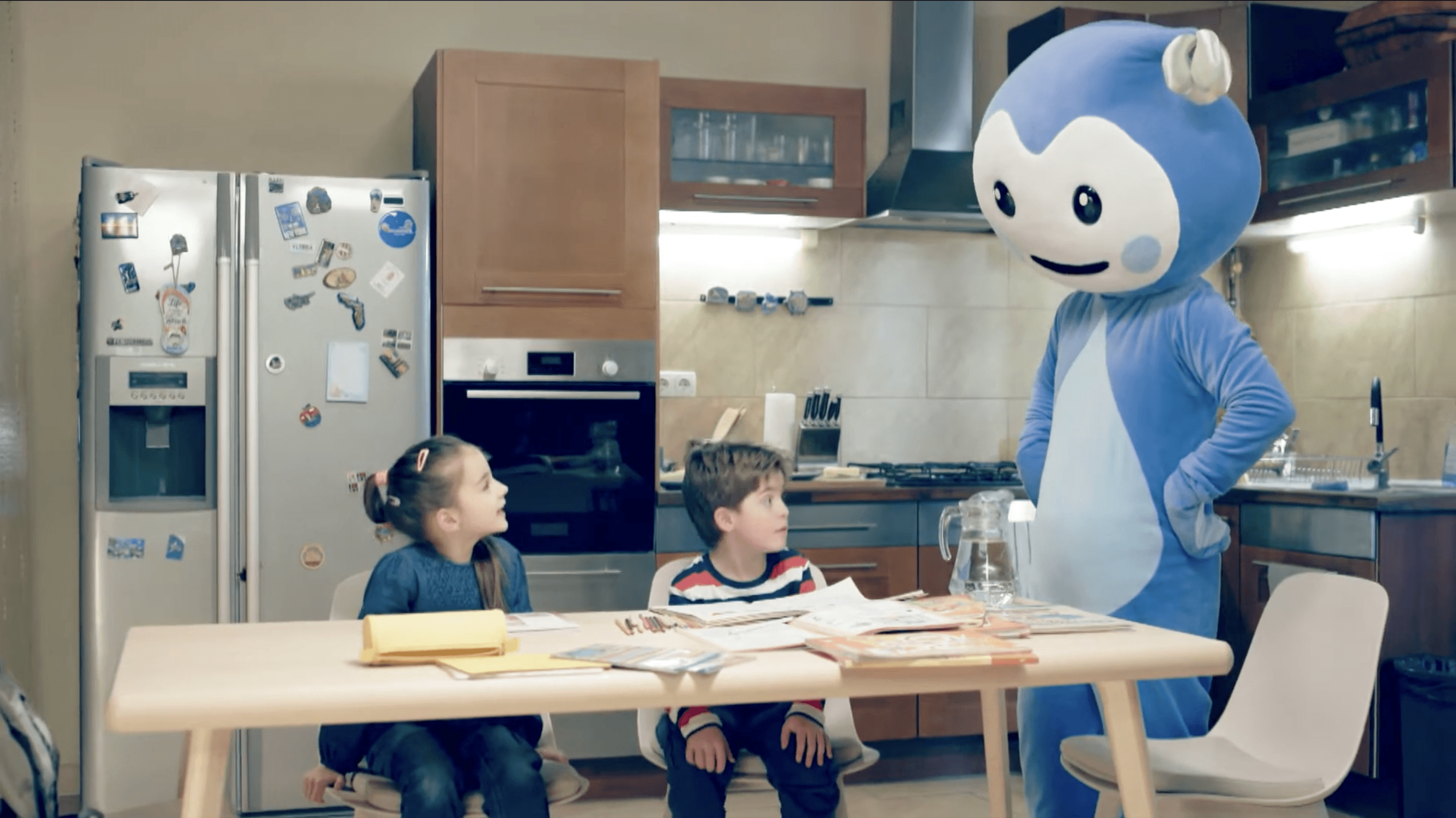 Cseppbarát kék kabalafigurája a konyhában asztalnál tanítja a gyerekeket