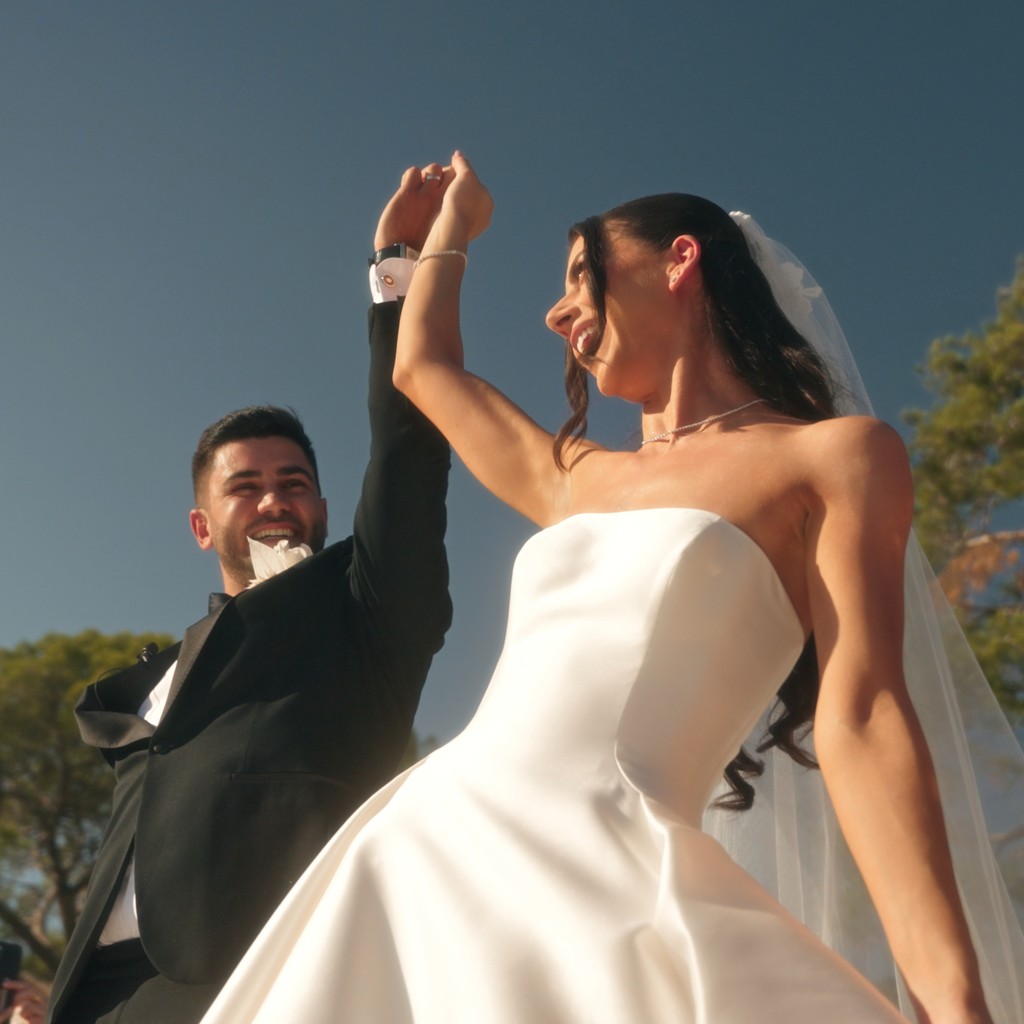 Woman in bathrobe holding champagne glass on bed.