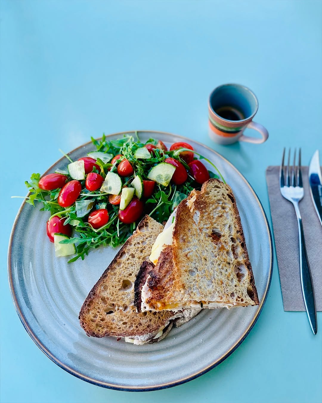 Birds eye veiw of meal with coffee mug and knife and fork.