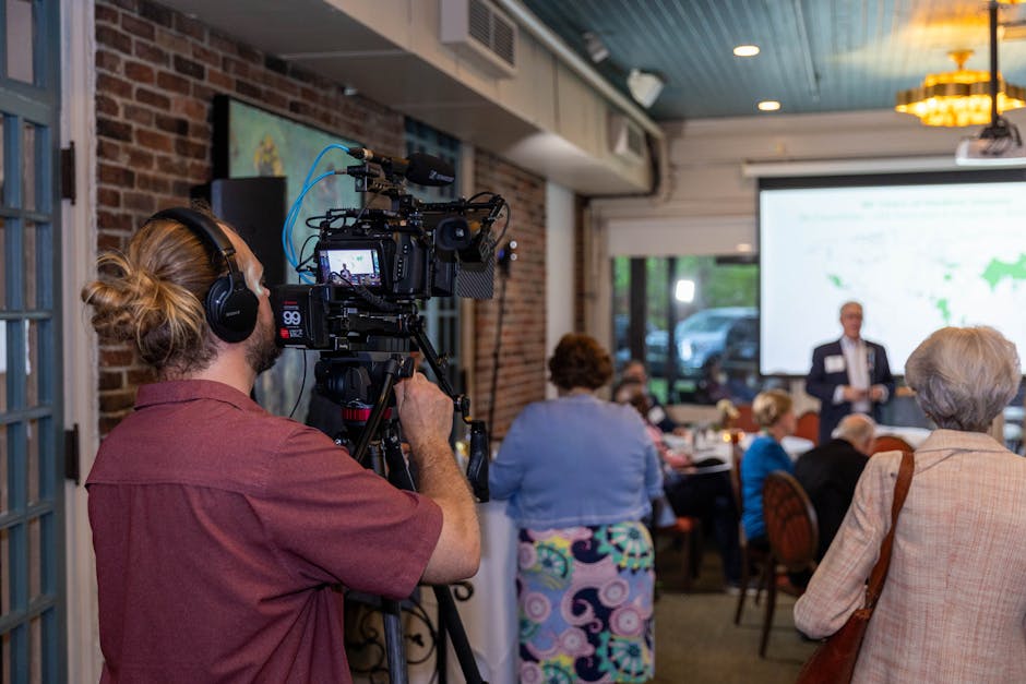 videographer capturing candid networking moments at a corporate summit - corporate event highlight reel