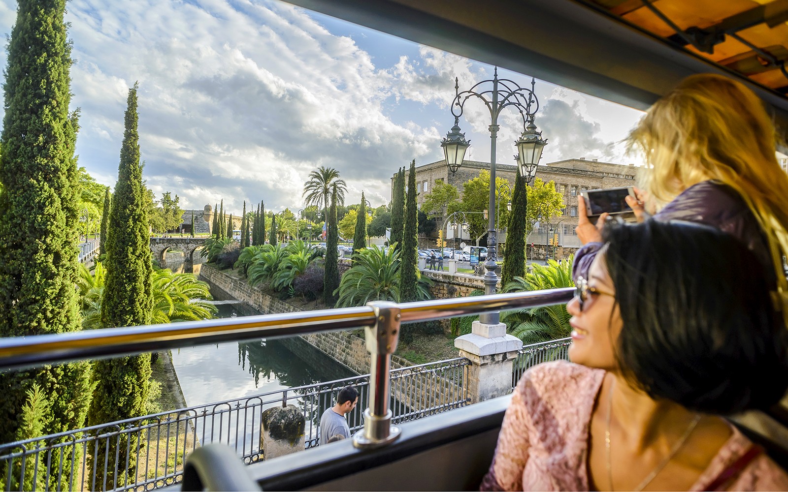 Una señora disfrutando de la vista desde el autobús turístico de subidas y bajadas durante 24 horas en un paisaje urbano panorámico.