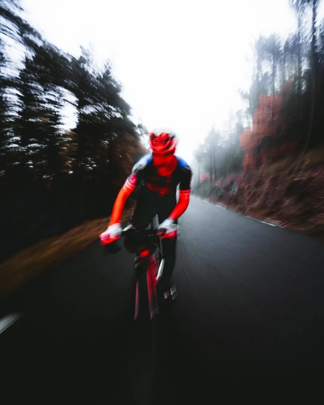Photographie de cycliste de nuit sous éclairage rouge pour l'ambiance du défi sportif.