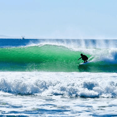 Surfer riding a green wave – surfboard rental in santa-barbara.