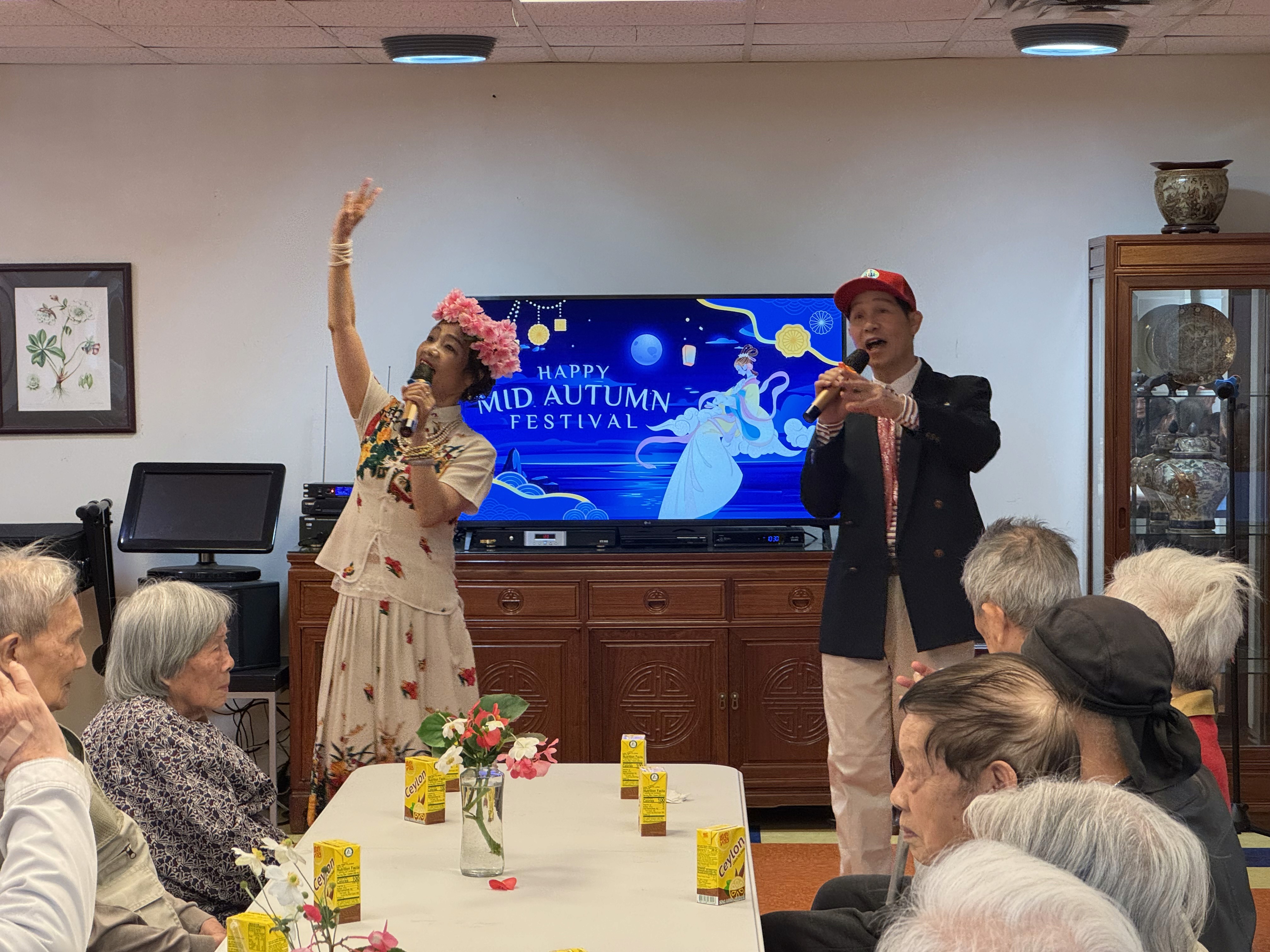 Two musical performers serande seniors with a Happy Mid Autumn Festival message.