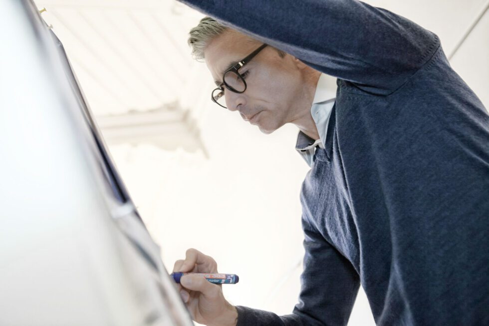 woman in blue tank top standing beside white wall