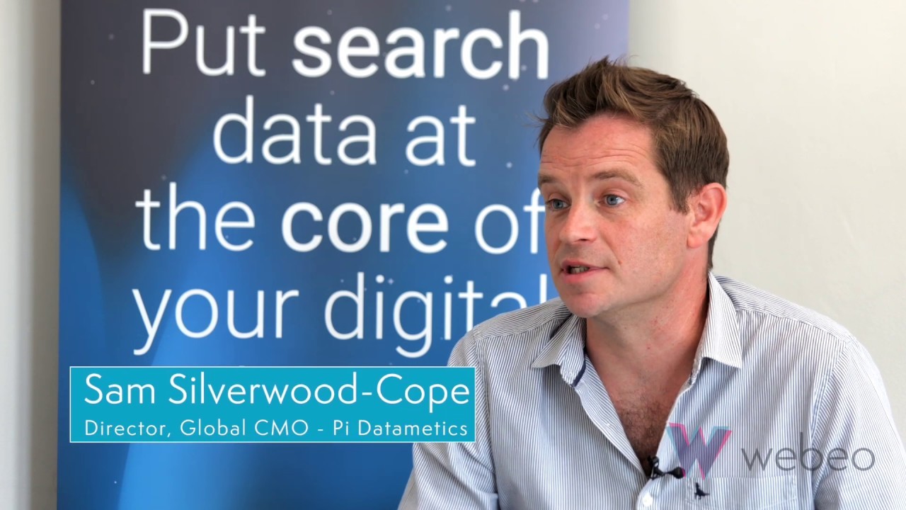 man wearing blue polo shirt with building background