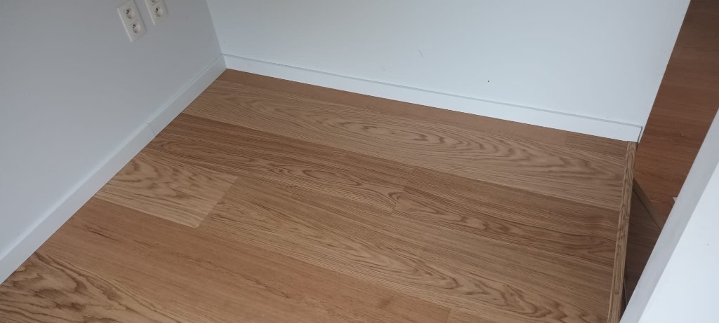 Detailafwerking parketvloer langs plint en muur